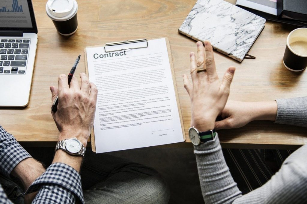 Twee mensen bespreken een contract op een tafel